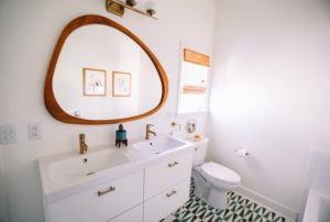 A Edmonds bathroom with a large vanity, a double sink, a large mirror, and a toilet.