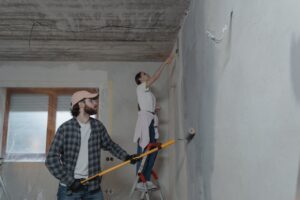 A man and a woman painting a blank wall.