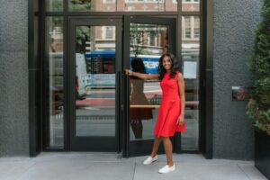 A woman opening a door to an apartment building.